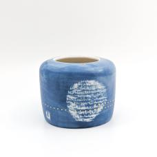 White vase painted blue on the outside and accented with gold dots and persian writing.