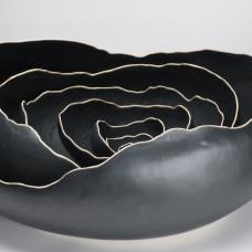 Nesting black porcelain bowls formed with a wooden paddle and river stone.