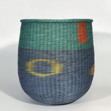 Basket woven with twining technique to create the spirals and a traditional tapestry technique to achieve patches of contrasting color.
