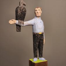 Vulture Perched on the arm of a man. Carved from reclaimed lumber.