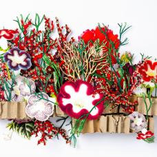 This is a hand cut 3d paper sculpture featuring elements of coral and ocean environments. It uses recycled materials as its structure