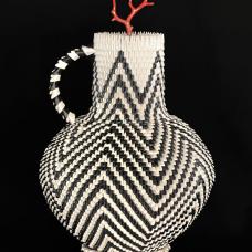 This piece was inspired by a trip to the Field Museum in Chicago. At the museum  they showcased hundreds of ancestral pottery from ancestral sites like Mesa Verde and Chaco Canyon. Walking into the exhibit  it felt like all the pottery was singing and I greeted every one. This visit inspired me to create my own version of a pitcher with a radiating star design and features a lid with a Mediterranean coral branch  giving a double water symbolism.