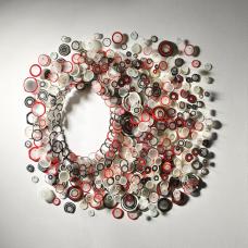 This is a wall installation that holds a necklace that one can take out of the piece and wear. The installation is made from blown  carved and sewn glass with insect pins  seed beads and wood.