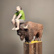 Figure sitting on the head of a Bison. Carved from Reclaimed lumber.