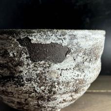 The Volcanic fields bowl is thrown from a dark clay body  altered with a spiral design  and decorated with several layers of heavily textured slip in a process designed to allow the slip to crackle and in some areas release to reveal bare clay. The piece has been lovingly sanded to its final finish. Inspired by the moss and lichen covered lava fields of Iceland.