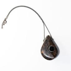 Hand shaped and polished Black Palm Wood with gradient oxidized silver prong and custom clasp. A locking system is employed to bond the metal and wood. A keyhole system is drilled within the wood and the metal is knurled before epoxying wood and metal together.