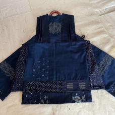 This piece is the result of an experiment to transform indigo-dyed  cotton fabric into a creative image that mirrors the shapes and three-dimensional structure of origami. The various shades of indigo are decorated with stitches sourced from plant-based dyed thread.