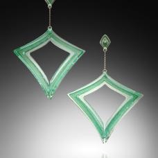 Digitally designed  waterjet cut glass  coldworked  polished  fused and laminated together to form two 3-dimensional glass forms. Sterling Silver posts are embedded into one while the second is suspended from a gold fill chain.