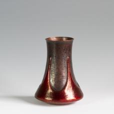 This vase is hand raised from a single sheet of copper. The form is then chased and textured before a vivid red patina is applied.