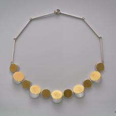 Necklace features 11 circular tubes that were intentionally tilted and cut to create varying perspectives reducing its perceived simplicity