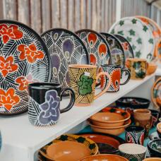 shelf full of colorful plates and mugs