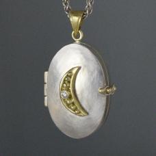 silver and gold charm with crescent moon