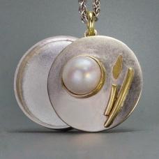 round silver, gold, and white charm