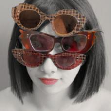model wearing three pairs of glasses stacked