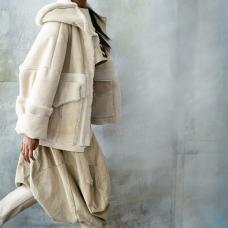 model wearing light shearling coat with baggy pants and boots