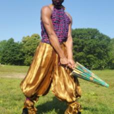 model with baggy pants and sleeveless top holding a closed parasol