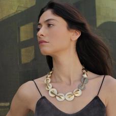 This artistic collar necklace is made by pinching two circles and connecting them until they barely touch  adding to the tension between them.