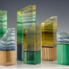 Six cast and cold-worked glass creations. These started out as 4 blocks created in a kiln  then sawed into multiple pieces. Colored epoxy joined two of these smaller pieces together. Grinding and polishing completed each piece. Underlighting is included.