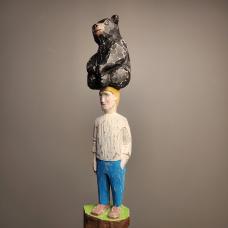 Bear sitting on the head of a man. Carved from Reclaimed lumber
