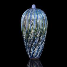 Colored glass cane are rolled up  covered with clear glass and blown into form. Lined with silver foil and given its final shape.