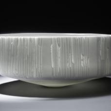 Wheelthrown poorcealin. Surface is handcarved by slicing and lifting thin strips from the vessels's surface to emphasize translucency 